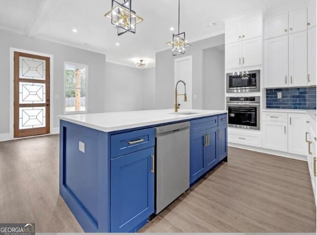 3312 Mill Forest Dr, Conyers, GA 30094 - kitchen featuring stainless steel appliances, blue cabinetry, a sink, and light wood finished floors