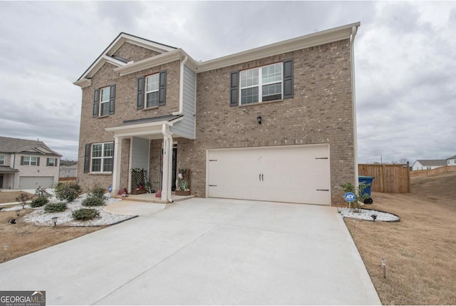craftsman house featuring brick siding, a garage, fence, and driveway