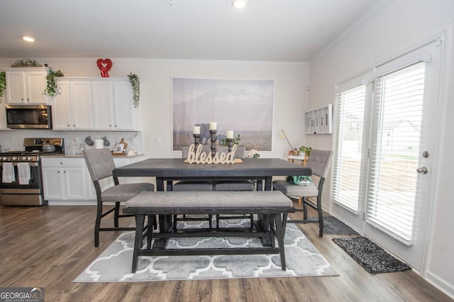 dining space with recessed lighting, ornamental molding, and wood finished floors