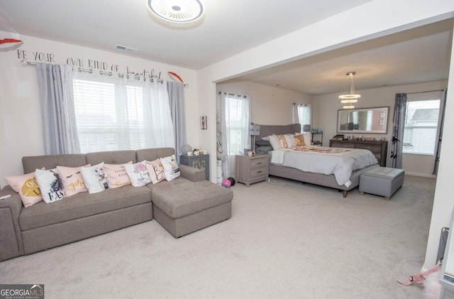 carpeted bedroom with visible vents and multiple windows