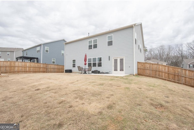 back of house featuring a yard, fence, and french doors