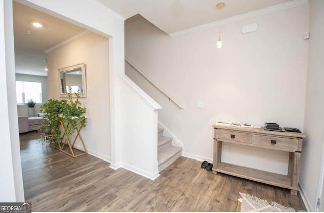stairs featuring crown molding, baseboards, and wood finished floors