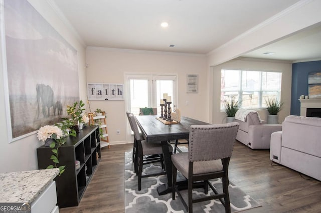dining room with crown molding, recessed lighting, dark wood finished floors, and a fireplace