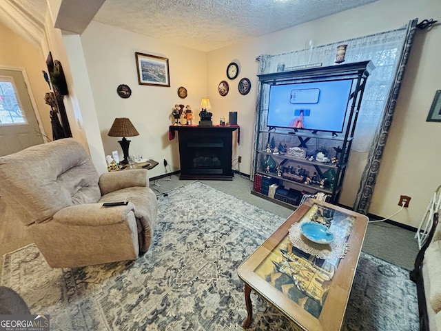 living area with a fireplace, baseboards, carpet, and a textured ceiling