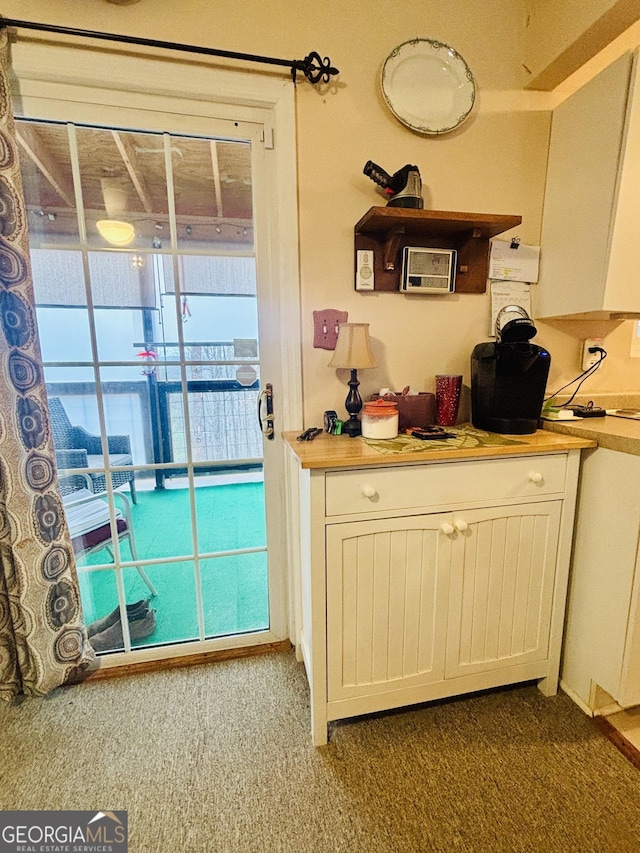 kitchen featuring carpet flooring, white cabinetry, and light countertops