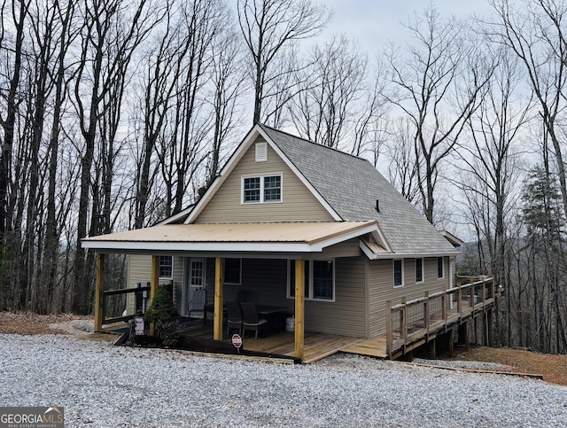 view of front of property with a porch and roof with shingles