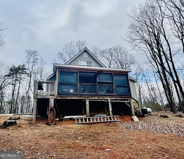 rear view of property featuring a wooden deck