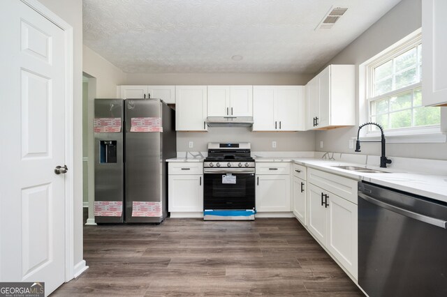 3230 Deer Valley Dr NW, Acworth, GA 30101 - kitchen featuring appliances with stainless steel finishes, a sink, under cabinet range hood, white cabinetry, and a textured ceiling