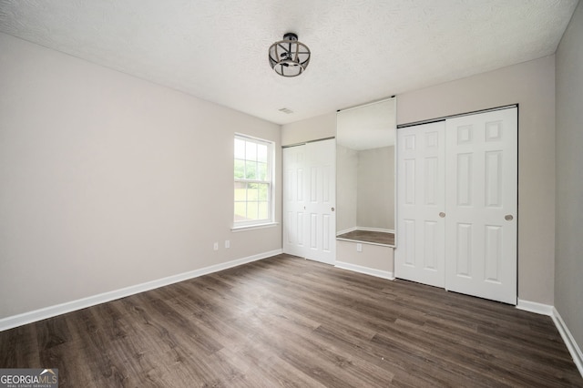 3230 Deer Valley Dr NW, Acworth, GA 30101 - unfurnished bedroom featuring two closets, dark wood-style floors, baseboards, and a textured ceiling