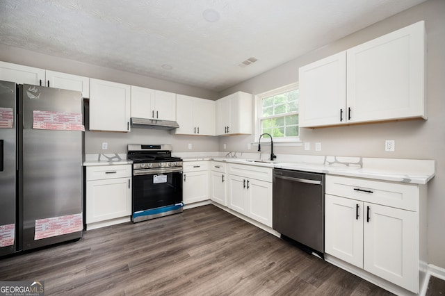 3230 Deer Valley Dr NW, Acworth, GA 30101 - kitchen with stainless steel appliances, a sink, under cabinet range hood, white cabinets, and dark wood-style flooring