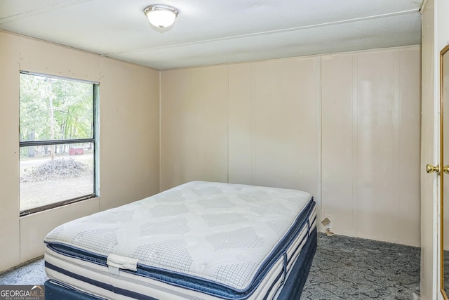 carpeted bedroom featuring a decorative wall