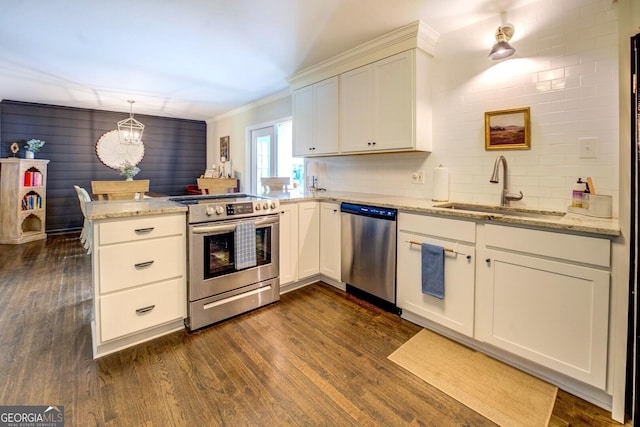 kitchen featuring dark wood finished floors, a sink, a peninsula, a chandelier, and stainless steel appliances