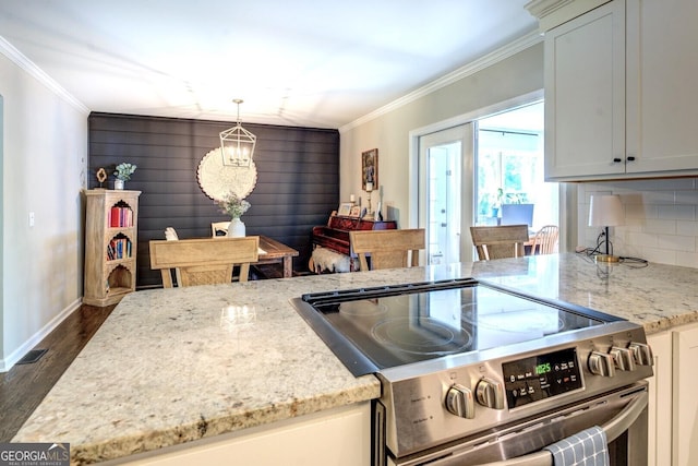 kitchen featuring crown molding, electric stove, baseboards, and dark wood-type flooring