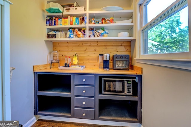 bar with a dry bar, plenty of natural light, and stainless steel microwave