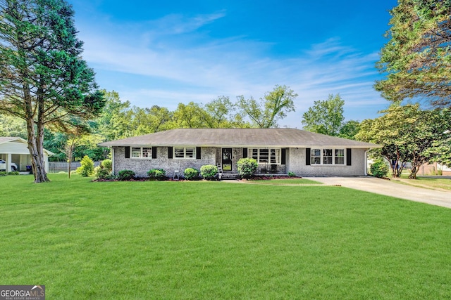 single story home with brick siding, fence, driveway, and a front yard