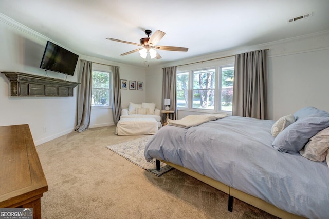 carpeted bedroom with crown molding, baseboards, ceiling fan, and visible vents