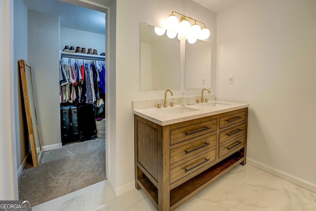 full bathroom featuring double vanity, baseboards, a sink, and marble finish floor