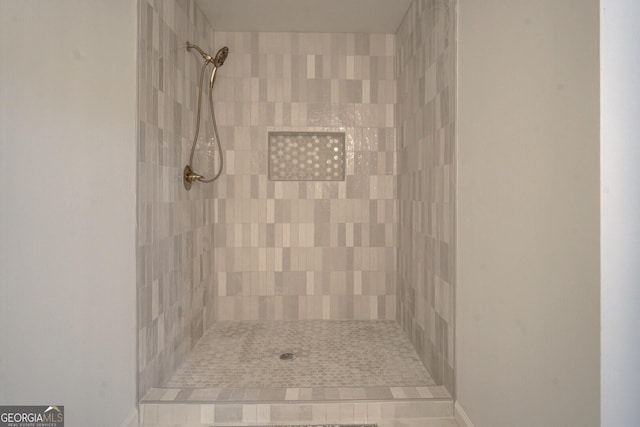 bathroom with baseboards and a tile shower