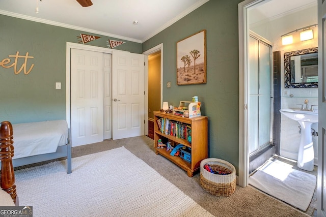 carpeted bedroom with ornamental molding, a ceiling fan, and a closet