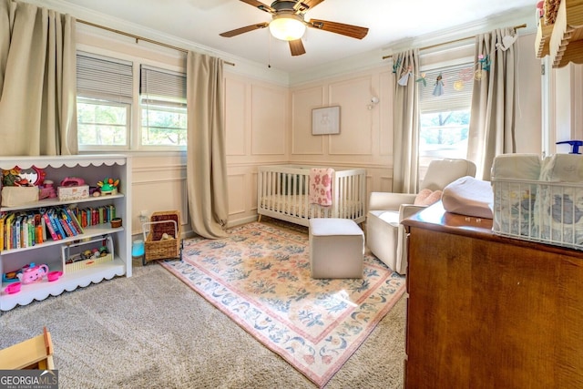 carpeted bedroom featuring a nursery area, multiple windows, and a decorative wall