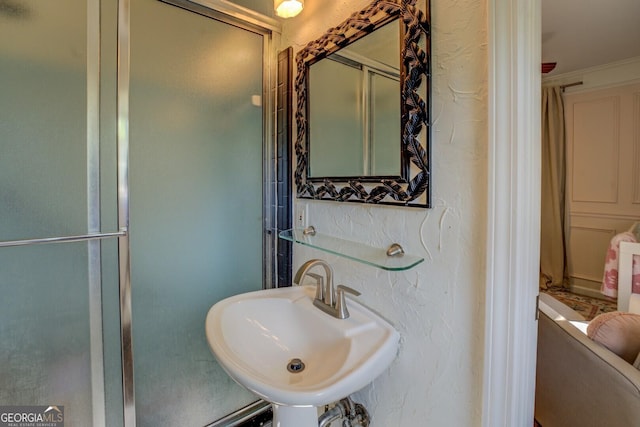 bathroom with an enclosed shower and a sink