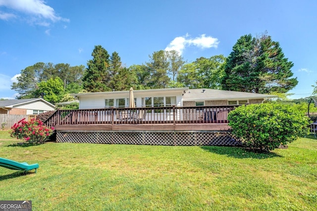 rear view of property with a lawn and a wooden deck