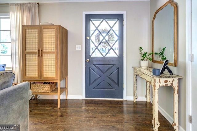 foyer featuring baseboards and wood finished floors