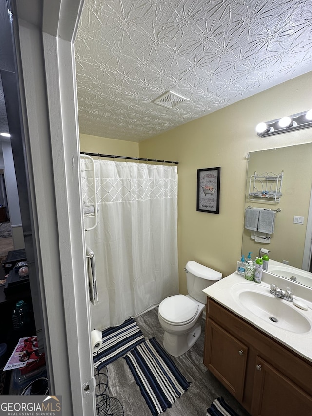 bathroom featuring vanity, toilet, a shower with curtain, and visible vents