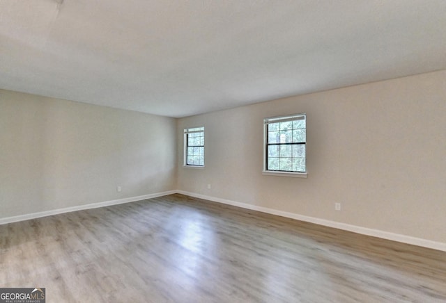 empty room featuring baseboards and wood finished floors