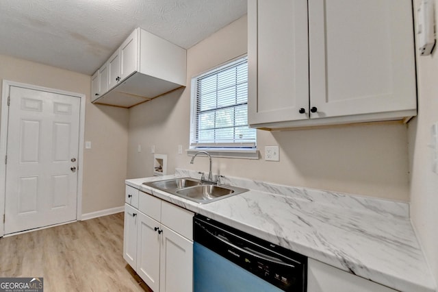 kitchen featuring white cabinetry, a sink, dishwashing machine, and light wood-style floors