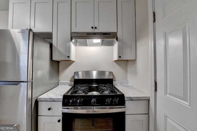 kitchen featuring freestanding refrigerator, under cabinet range hood, black range with gas cooktop, and light stone countertops