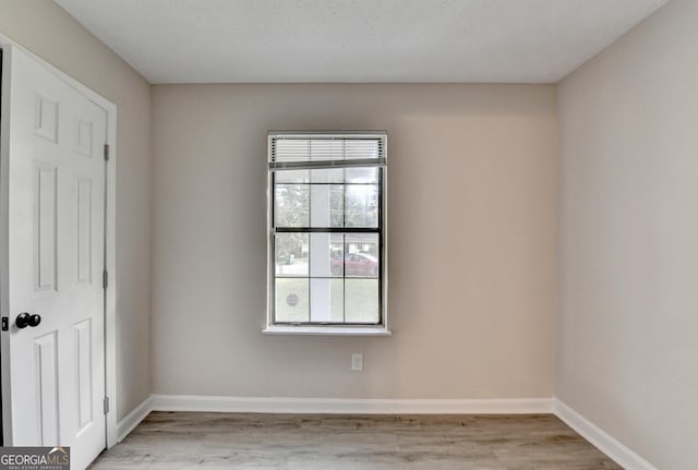 empty room featuring light wood-style floors and baseboards