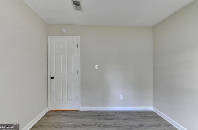 empty room with light wood-style floors, baseboards, and visible vents