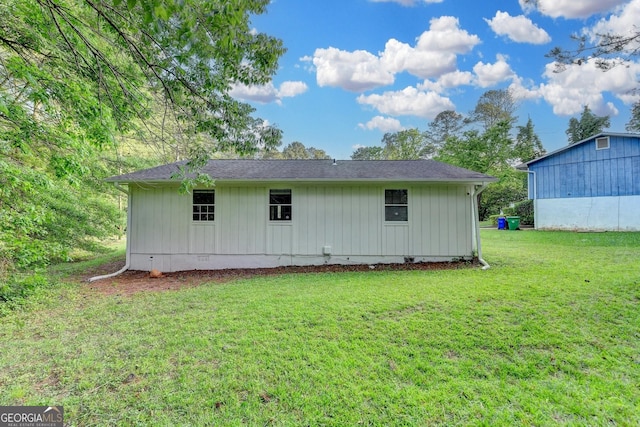 rear view of house featuring a yard
