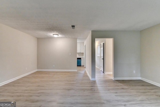interior space with light wood-style floors, baseboards, and visible vents