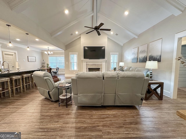 living room featuring beam ceiling, dark wood-type flooring, baseboards, and ceiling fan with notable chandelier
