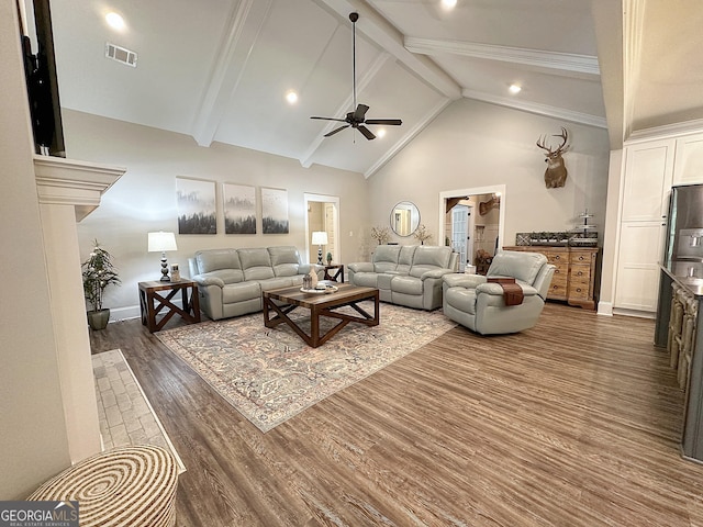 living area with baseboards, ceiling fan, visible vents, wood finished floors, and vaulted ceiling with beams