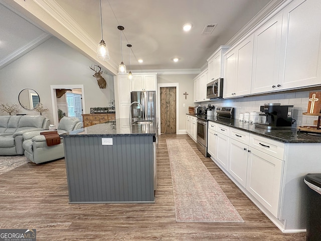 kitchen with stainless steel appliances, a sink, visible vents, and decorative backsplash