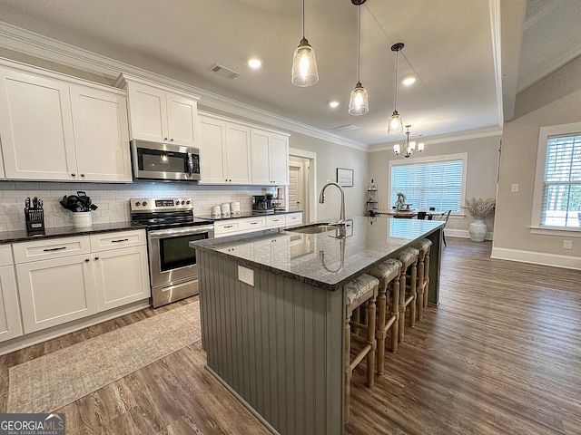 kitchen with a sink, dark wood-style floors, visible vents, and appliances with stainless steel finishes