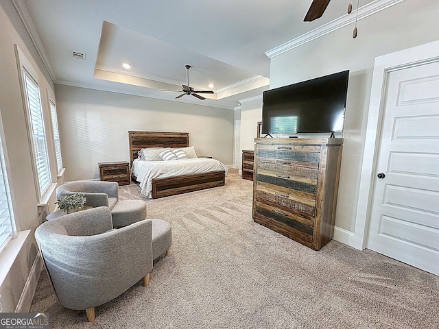 bedroom featuring carpet, a tray ceiling, visible vents, baseboards, and ornamental molding
