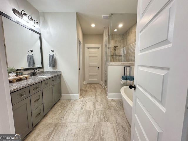 full bathroom featuring a freestanding bath, visible vents, baseboards, a shower stall, and vanity