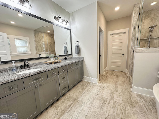 full bath with a shower stall, recessed lighting, double vanity, and a sink