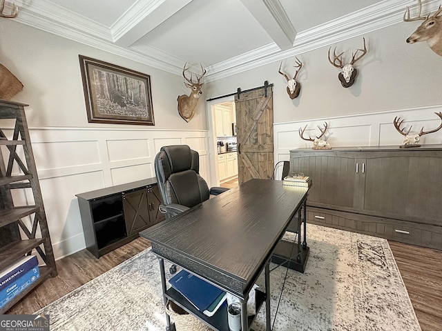 office featuring wood finished floors, crown molding, a decorative wall, wainscoting, and a barn door