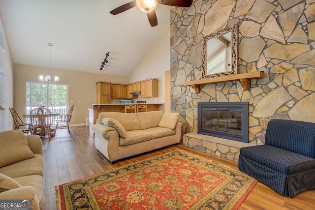 2787 Turtle Cove Trwy, Monticello, GA 31064 - living room with wood finished floors, high vaulted ceiling, ceiling fan, a chandelier, and a stone fireplace