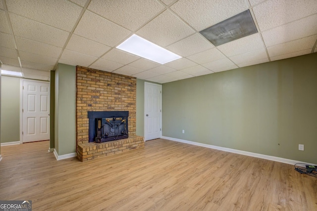 2787 Turtle Cove Trwy, Monticello, GA 31064 - unfurnished living room featuring light wood-style flooring, a fireplace, a drop ceiling, and baseboards