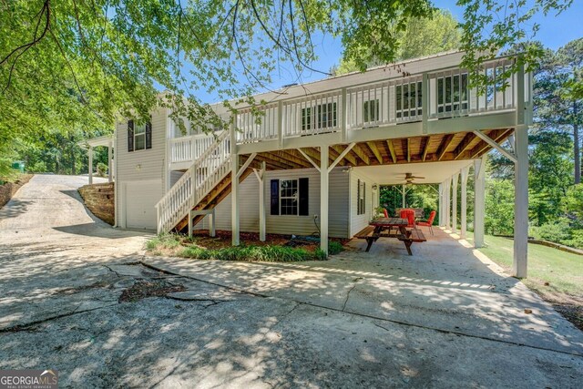 2787 Turtle Cove Trwy, Monticello, GA 31064 - back of house with driveway, a ceiling fan, a carport, stairway, and a garage