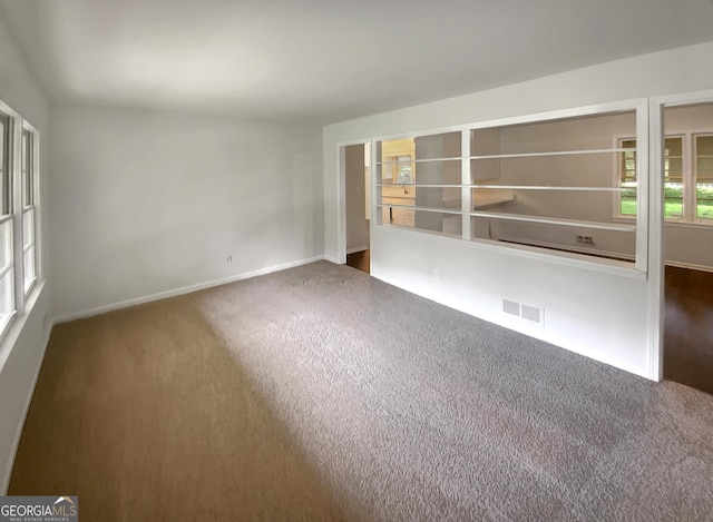 empty room with baseboards, carpet flooring, and visible vents
