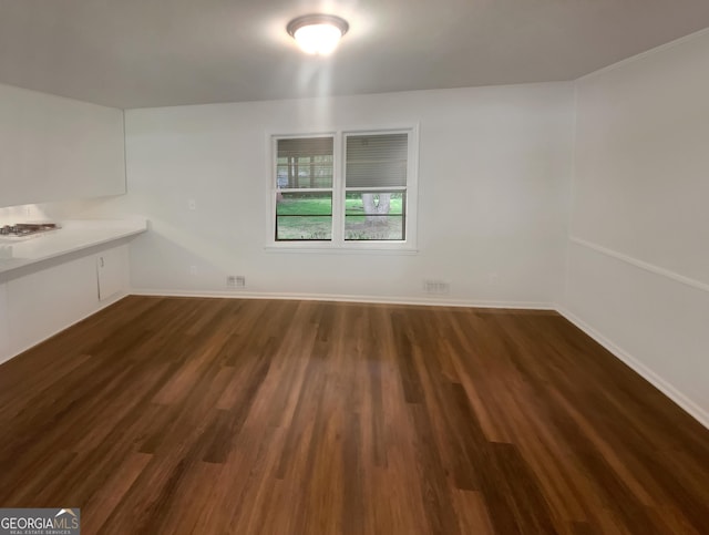 unfurnished dining area with baseboards and dark wood-type flooring