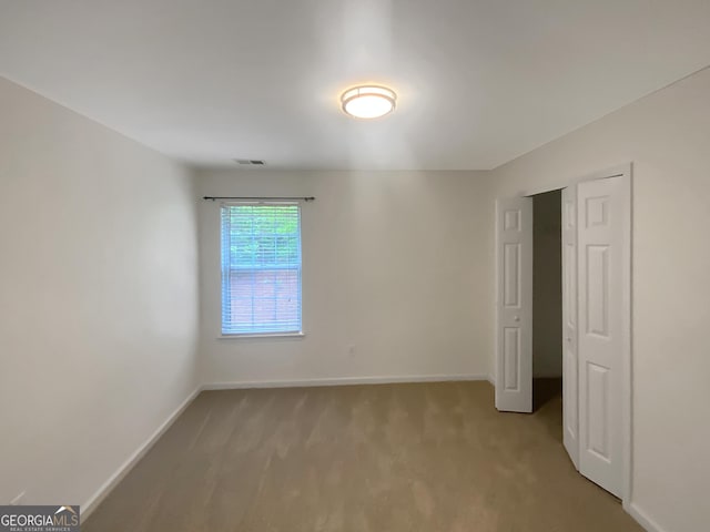unfurnished bedroom featuring visible vents, baseboards, and light colored carpet