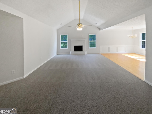 30 Trelawney Ct, Covington, GA 30016 - unfurnished living room featuring carpet floors, baseboards, a fireplace with raised hearth, ceiling fan with notable chandelier, and lofted ceiling